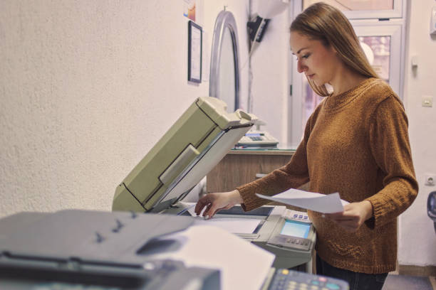 Woman putting a paper into a copying device