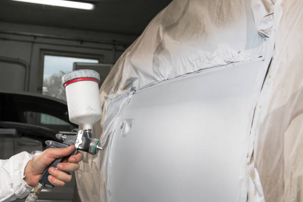 istock Painter spray gun in the hands of a painter. 911626400
