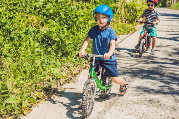 dwóch małych chłopców dzieci zabawy na rowerze balance na drodze tropikalnej kraju - 7971 zdjęcia i obrazy z banku zdjęć