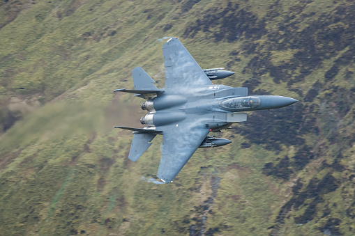 A F-15 from RAF Lakenheath travels at low level through the famous Machloop LFA7 training area in North Wales during a break in the weather system.