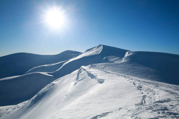 istock Snow-covered white peaks of mountains on sunny blue sky 911641896