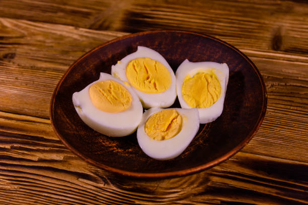 istock Ceramic plate with peeled boiled eggs on wooden table 911642264