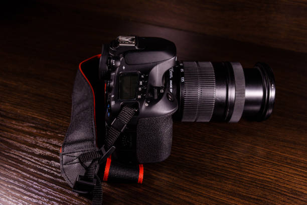 istock Modern dslr camera on the dark wooden table 911642326