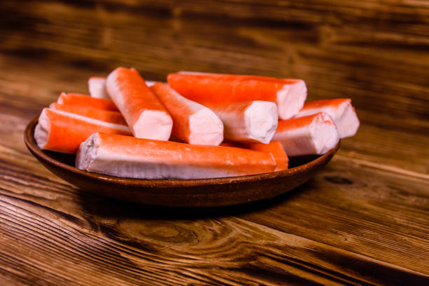 istock Ceramic plate with crab sticks on wooden table 911642680