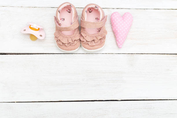 rosa zubehör für baby-mädchen auf einem hölzernen weißen hintergrund. textfreiraum - saddle shoes stock-fotos und bilder