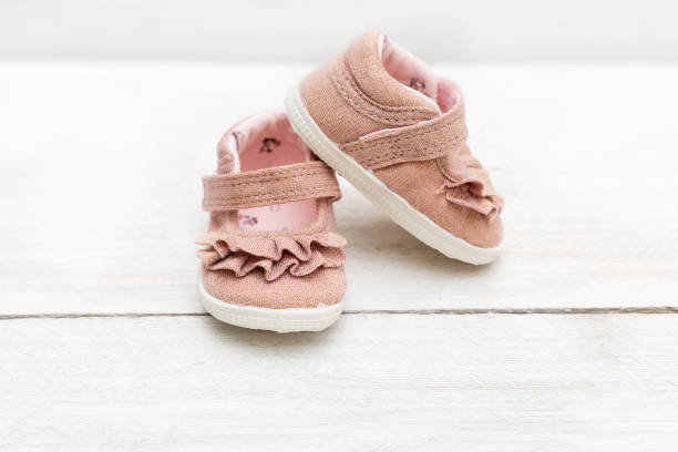 子供の靴はピンク木製の背景に女の赤ちゃんのための色です。ファッションベビー - saddle shoes ストックフォトと画像