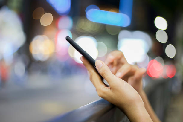 istock Women using smartphone on street night 911660296