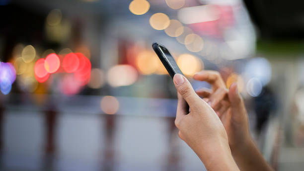 istock Women using smartphone on street night 911660974