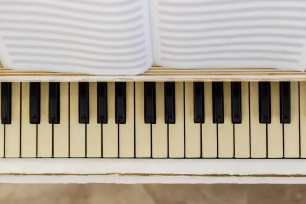 Photo of Piano close-up, musical instrument. learn to play the instrument at home. white large piano. piano keyboard. concert concept.