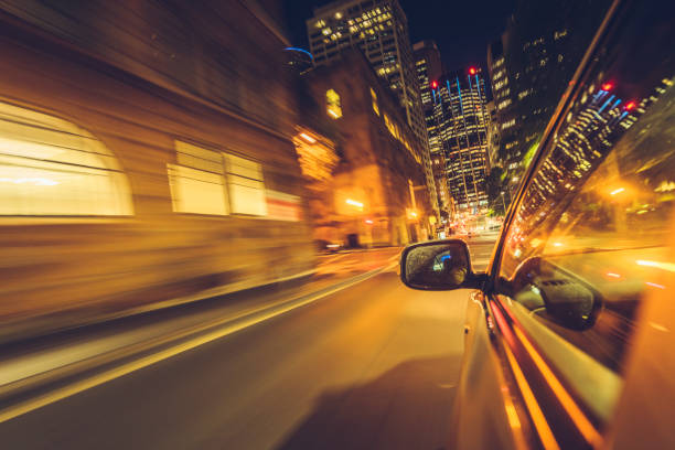 istock car driving at night in downtown sydney 911668494