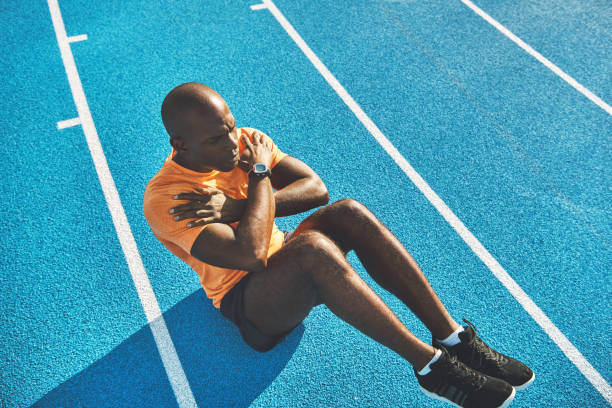 istock Fit young athlete doing crunches on a track outside 911668568