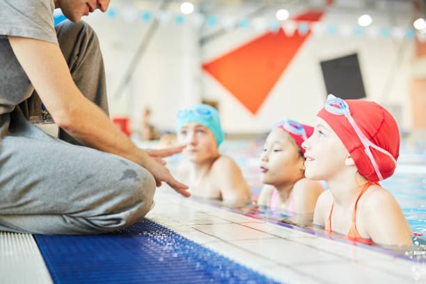 mali uczniowie - swimming child swimming pool indoors zdjęcia i obrazy z banku zdjęć