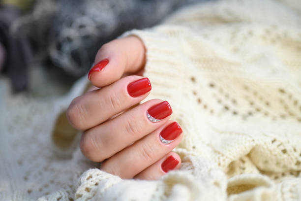 istock Hands with long artificial manicured nails colored with red nail polish 911674968