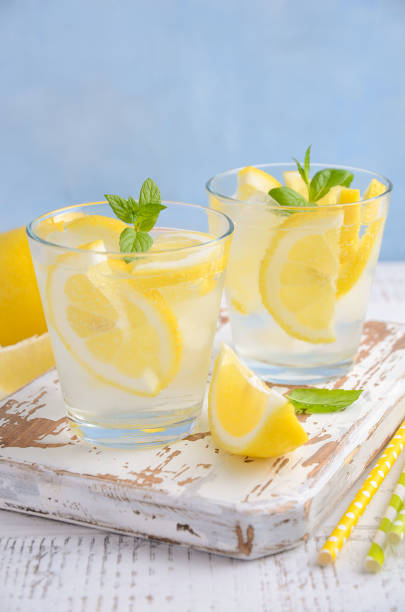 istock Cold refreshing summer drink with lemon and mint on wooden background. 911678960