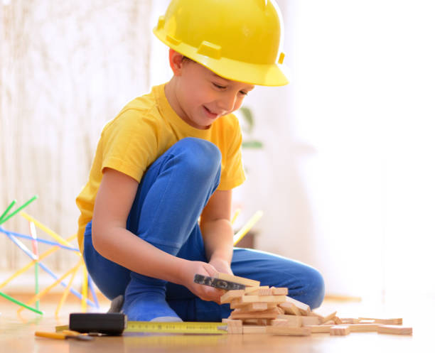 istock Beautiful boy is playing with toy blocks and hand tools 911679800