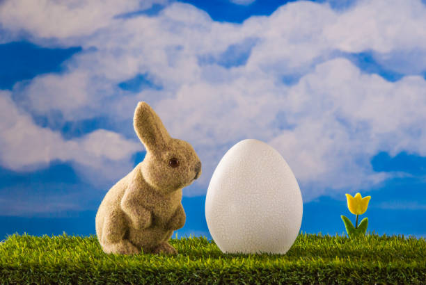 Spring landscape. Rabbit look at immense egg with craquelure.