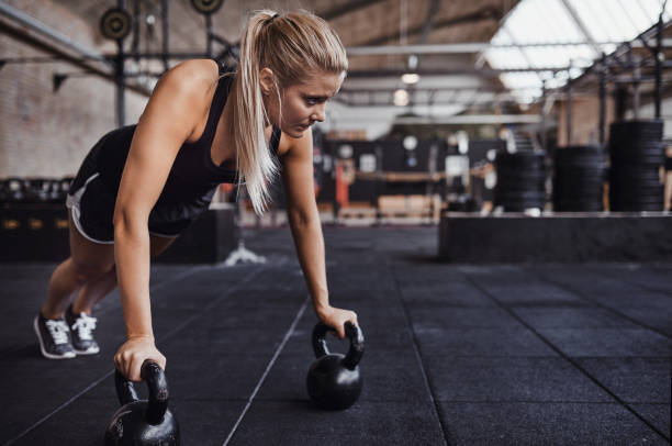 istock Focused young woman weight training on a gym floor 911681336