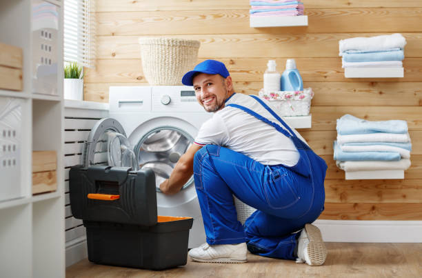istock working man   plumber repairs  washing machine in   laundry 911681358