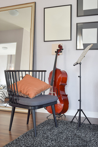 cello or violoncello musical instrument with wooden chair and pillow at home