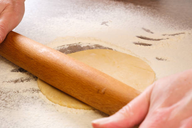 istock Unleavened dough for tortillas with rolling pin on kitchen table. Cooking burrito. 911687022