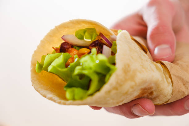 istock Mexican burrito in hand with chicken, pepper and beans 911687214