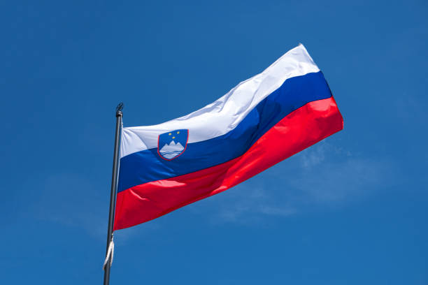 istock Flag of Slovenia waving in wind, blue sky backdrop 911687284