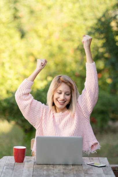 istock Cheerful young woman celebrating success 911689432