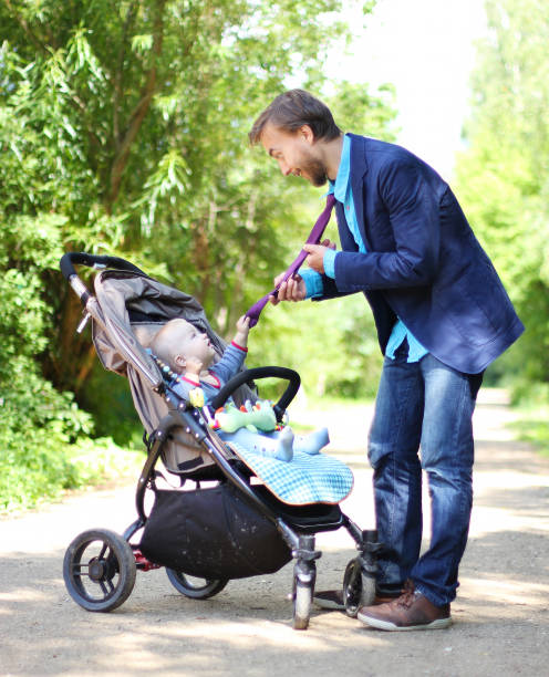 istock infant in a pram holds his father by the tie 911690540