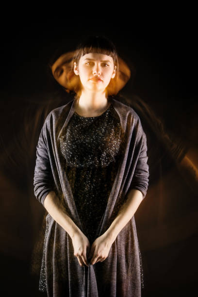 istock Girl with blurred silhouettes on a black background. 911691068