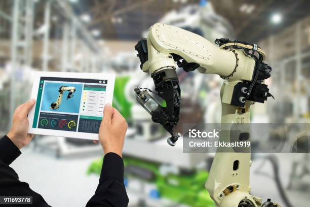 Iot Industry 40 Conceptindustrial Engineer Using Software In Tablet To Monitoring Machine In Real Timesmart Factory Use Automation Robot Arm In Automotive Manufacturing Stock Photo - Download Image Now