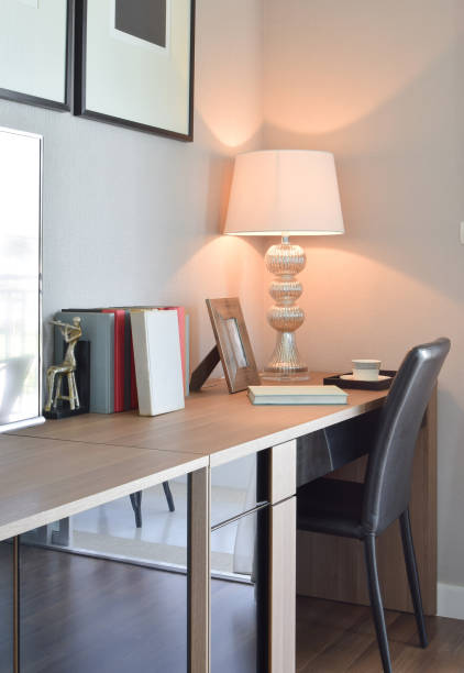 istock wooden table with lamp and books in modern working room interior 911694064