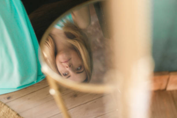 istock Woman reflection in glass table at home 911695806