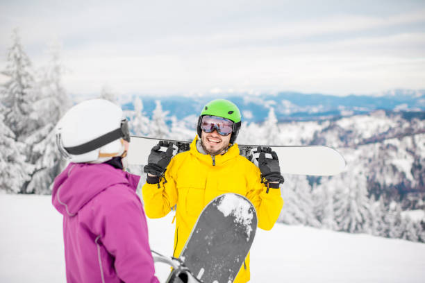 istock Couple with snowboards on the snowy mountains 911700906