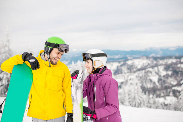 istock Couple with snowboards on the snowy mountains 911702278