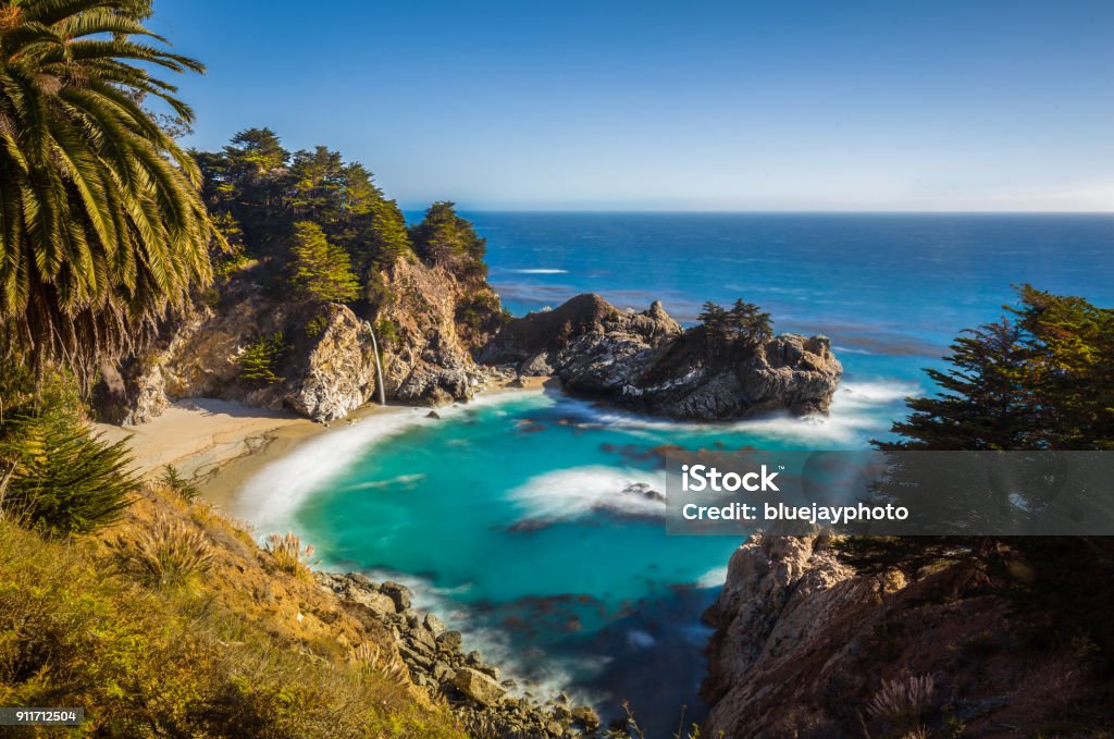 McWay Falls at sunset, Big Sur, California, USA Classic postcard view of famous McWay Falls in scenic golden evening light at sunset on a beautiful sunny day with blue sky in summer, Julia Pfeiffer Burns State Park, Big Sur, California, USA Carmel - California Stock Photo