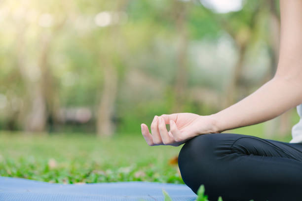 istock Young asian woman yoga outdoors keep calm and meditates while practicing yoga to explore the inner peace. Yoga and meditation have good benefits for health. Yoga Sport and Healthy lifestyle concept. 911720492