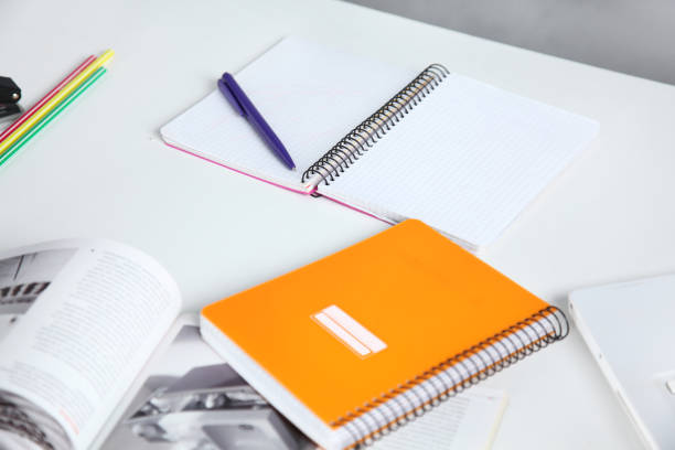 istock Colorful notebooks and office supplies on white table. 911723420