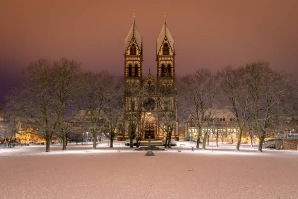 The "Herz Jesu" church in Freiburg on a snowy morning. The "Herz Jesu" church in Freiburg on a snowy morning. Taken from the blue bridge showing the church and the beautiful "Stühlinger" park. The clouds and the light of the city give some great colors. black forest photos stock pictures, royalty-free photos & images