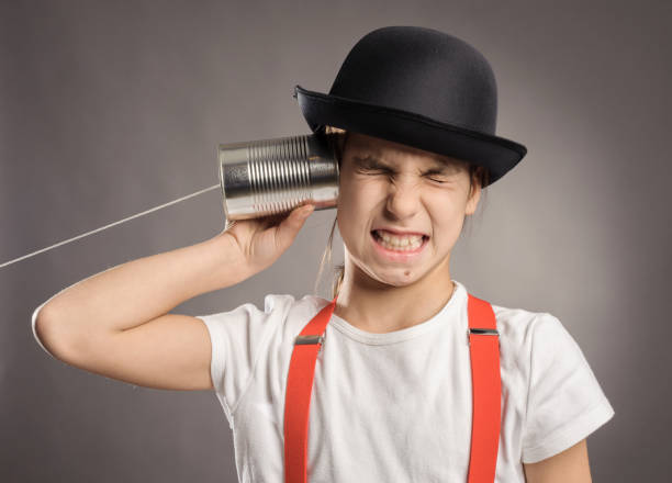 istock little girl using a can as telephone 911731650