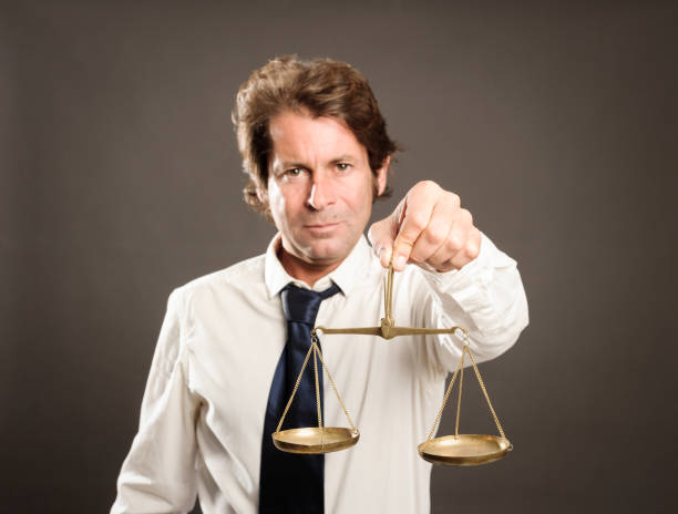 istock businessman holding a justice scale 911731760