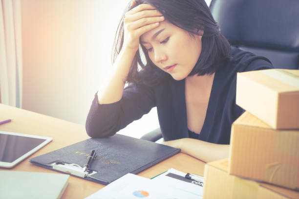 istock Tired Asian office woker with hand on her head getting headache 911732358