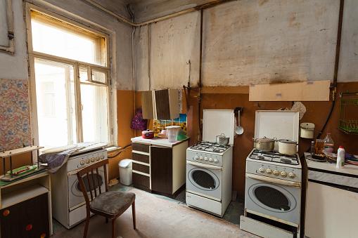 Dirty kitchen with furniture and gas stoves  is in the apartment for temporary  living (existence) refugees who were forced to migrate and emigrate from other countries.