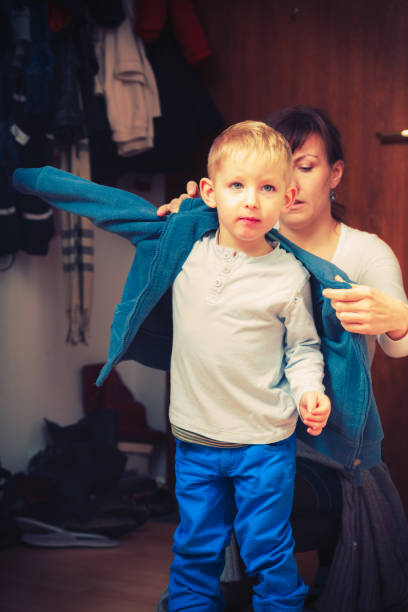 istock Mother dressing up her son in winter clothes 911735872