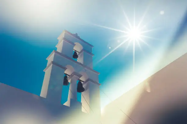beautiful colors on traditional greece clocktower with bright sun flare.