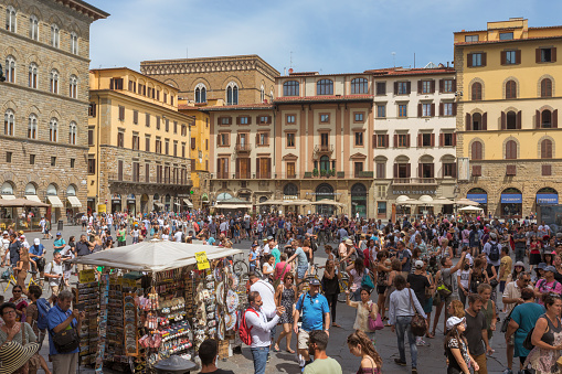 A summer day with crowds of tourists on the central Piazza della Signoria, a city square in Florence, Italy.