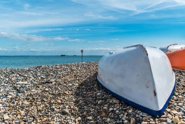 Upturned dinghy on a beach at the end of the sailing season