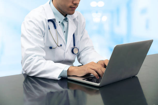 istock Doctor working on desk with laptop 911749916