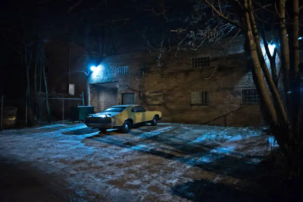 Photo of Vintage muscle car in a dark Chicago city urban alley on a winter night.