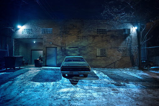 Vintage muscle car in a dark Chicago city urban alley on a winter night.