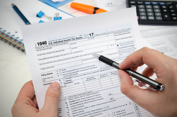 istock Man filling US tax form. 911758558